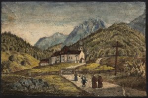 Eine Gruppe von Menschen geht einen Weg entlang in Richtung eines großen Gebäudes und einer kleinen Kirche in Hinterriß, inmitten einer bergigen, bewaldeten Landschaft bei bewölktem Himmel.