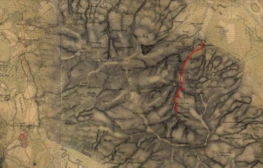 Eine alte topografische Karte zeigt Geländemerkmale mit einer roten Linie, die einen bestimmten Weg oder eine Grenze über Hügel und Täler markiert.