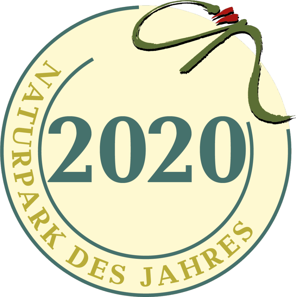 Ein kreisförmiges Abzeichen mit dem Schriftzug "Naturpark des Jahres 2020" am Rand, "2020" in der Mitte und einem grün-roten Pinselstrichmuster in der oberen rechten Ecke.