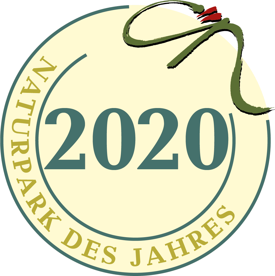 Ein kreisförmiges Abzeichen mit dem Schriftzug "Naturpark des Jahres 2020" am Rand, "2020" in der Mitte und einem grün-roten Pinselstrichmuster in der oberen rechten Ecke.