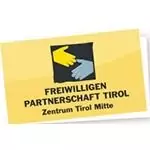 Gelbe Karte mit dem Logo von zwei Händen, einer gelben und einer blauen, die sich partnerschaftlich die Hand geben, über dem Text "Freiwilligen Partnerschaft Tirol Zentrum Tirol Mitte.