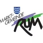 Logo der Marktgemeinde Rum mit stilisiertem schwarzem Text und einem abstrakten Muster in Blau, Weiß, Grün und Lila über dem Wort "Rum", das die Rolle der Gemeinde als Partner hervorhebt.