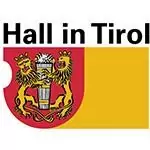 Wappen mit zwei Löwen, die einen Turm halten, auf einem rot-gelben Schild, das Stärke und Einheit symbolisiert, mit dem Text "Hall in Tirol" darüber - ein stolzer Partner im Erbe.
