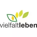 Das Bild zeigt das Wort "vielfaltleben" mit einer Grafik von vier Blättern über dem Text, zwei grüne und zwei gelbe, die Wachstum und Partnerschaft symbolisieren.